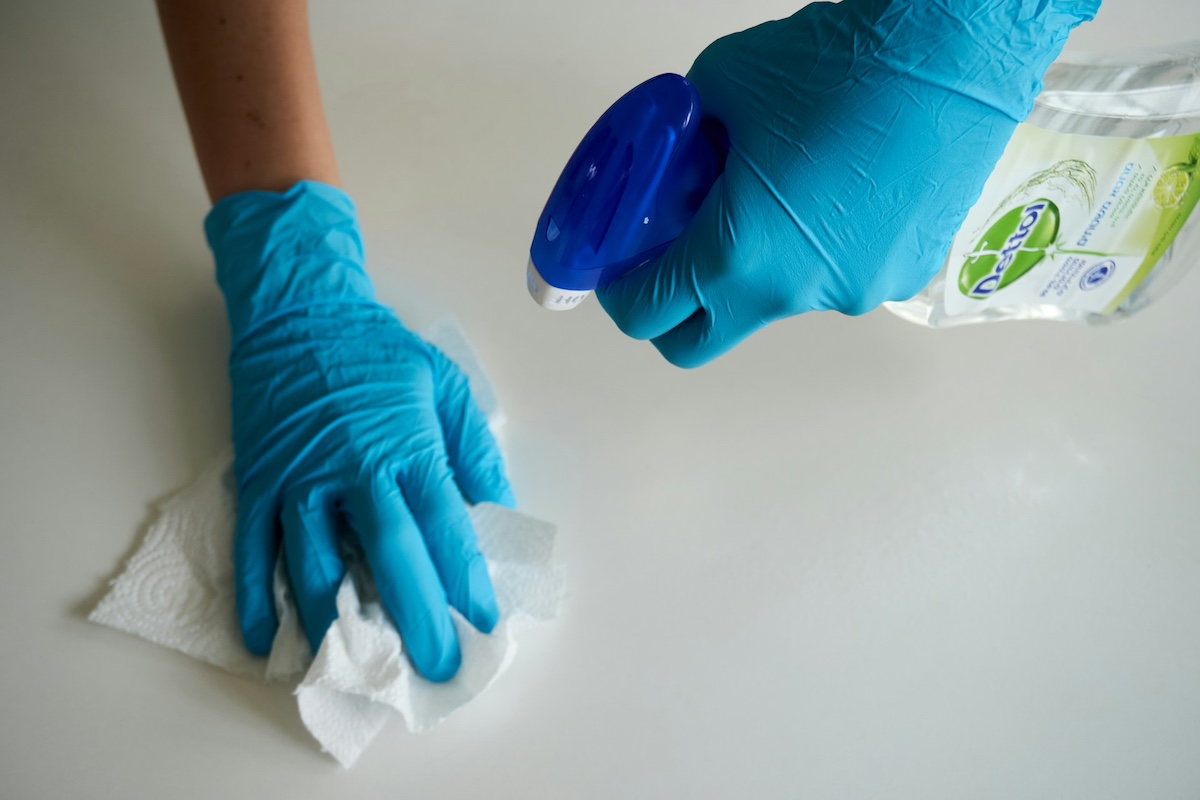 Person cleaning a home to avoid allergy triggers